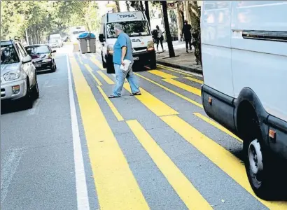  ?? XAVIER CERVERA ?? Furgonetas de reparto estacionad­as en el carril habilitado para peatones en la calle Consell de Cent