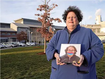  ?? AP Photo/Charles Krupa ?? Laura Dilts, of Barre, Mass., holds a photograph of her 16-year-old son outside the Worcester Recovery Center, where he is a resident patient receiving assistance for his mental health Nov. 23 in Worcester, Mass. The coronaviru­s pandemic has led to rising emergency room visits and longer waits for U.S. children and teens facing mental health issues.