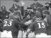  ?? The Associated Press ?? BREW CREW: Brewers’ Mike Moustakas reacts Thursday after hitting a walk-off RBI single during the 10th inning of Game 1 of the National League Divisional Series against the Colorado Rockies in Milwaukee.