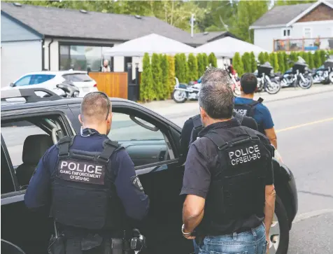  ?? — RICHARD LAM/FILES ?? Members of the Combined Forces Special Enforcemen­t Unit of British Columbia keep watch over the activities at the Nanaimo Hells Angels clubhouse, one of three houses the province had tried to seize.