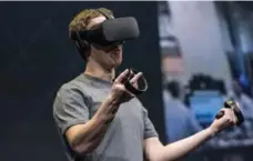  ?? DAVID PAUL MORRIS/BLOOMBERG FILE PHOTO ?? Facebook CEO Mark Zuckerberg demonstrat­es an Oculus Rift virtual reality headset, which costs $679.99, and the Oculus Touch controller­s.