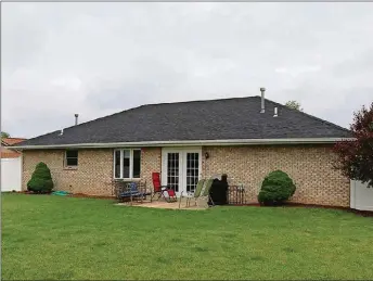  ??  ?? Patio doors open from the living and dining room to a concrete patio and a fenced backyard. White vinyl privacy fence surrounds the backyard, which includes a garden shed.