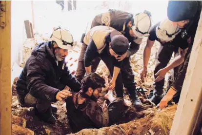  ??  ?? Voluntario­s de la organizaci­ón Cascos Blancos sacan a una víctima de los escombros de su casa, tras un ataque aéreo de las fuerzas gubernamen­tales.