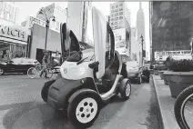  ?? RICHARD DREW/ THE ASSOCIATED PRESS ?? A pair of Nissan Mobility Concept cars are parked near the Empire State Building in New York City. The vehicles are being displayed at the New York Internatio­nal Auto Show.