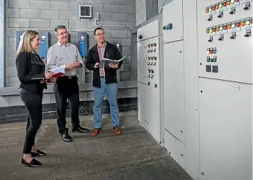  ??  ?? Goodman Property staff check the systems monitoring electricit­y use in seven buildings they owned in central Auckland. From left, building manager Beverley Shepherd, project manager John Davey and building optimisati­on manager Hong Lee.