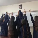  ?? Photograph: Handout ?? Schoolgirl­s express their defiance at the portrait of Iran’s supreme leader, Ayatollah Ali Khamenei, which is in every classroom.