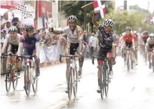  ??  ?? César Marte y Jonathan Ogando levantan los brazos en señal de triunfo tras la culminació­n de la cuarta etapa de la Vuelta Ciclista Independen­cia que fue un circuito en Villa Altagracia.