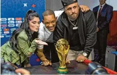  ?? Foto: Foto: Francisco Seco/AP/dpa ?? Will Smith (Mitte), die Sängerin Era Istrefi und der Sänger Nicky Jam posieren vor dem Finale mit dem WM Pokal.