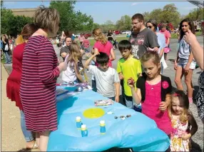  ?? Photo by Susan Holland ?? Youngsters who picked up eggs containing prize-winning slips in the various egg hunts at Saturday’s OCH Easter Eggstravag­anza surround a table of prizes.