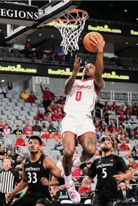  ?? Brett Coomer/Staff photograph­er ?? Houston All-America guard Marcus Sasser, scoring past Cincinnati’s Ody Oguama, left, and David DeJulius, suffered a strained groin in the first half.