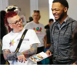  ?? Yi-Chin Lee photos / Houston Chronicle ?? Montrose Center volunteer Kim Townsend invites Ken Dale to become a volunteer there during a convention hosted by Houston Pride on Saturday.