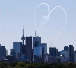  ?? BERNARD WEIL/TORONTO STAR ?? The Breitling Jet Team, left, is one of many performers at the air show. Framed by the Toronto skyline, the Snowbirds, right, send the city a message in smoke.