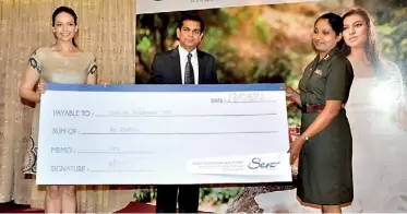  ??  ?? Shayana Raat handing over cash prize to the best student Corporal MPC Wijewardan­e while Malik Perera looks on