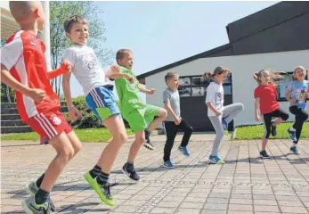  ?? FOTO: CAROLINE MESSICK ?? Die Schüler der Hausener Grundschul­e machen sich fit für den Verenalauf.