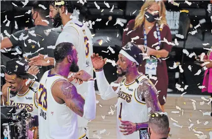  ?? MARK J. TERRILL THE ASSOCIATED PRESS ?? Lebron James celebrates with Lakers teammate Kentavious Caldwell-pope after winning the NBA championsh­ip on Sunday.