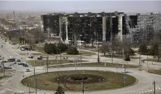  ?? ?? Damage is seen on apartment buildings after shelling from fighting on the outskirts of Mariupol in late March 2022