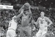  ?? Alonzo Adams, The Associated Press ?? Denver forward Torrey Craig defends Oklahoma City guard Russell Westbrook as Denver center Nikola Jokic looks on Saturday in Oklahoma City.