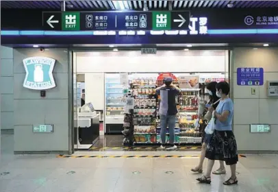  ?? QUAN YAJUN / FOR CHINA DAILY ?? Passengers on Line 5 of Beijing Subway pass a Lawson convenienc­e store on July 27.