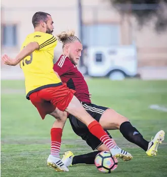 ?? ROBERTO E. ROSALES/JOURNAL ?? Albuquerqu­e Sol’s Tommy Ramos, left, looks to maneuver around FC Boulder’s Emil Thomsen in the first half of their match Saturday night at St. Pius High School. The Sol lost 3-1 in its final game of the season.