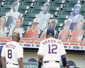  ?? Kevin M. Cox / Associated Press ?? Astros third base coach Gary Pettis and manager Dusty Baker Jr. gaze at photo cutouts of former Negro League players in a 100th anniversar­y celebratio­n of the Negro Leagues.