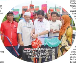  ??  ?? SADDI merasmikan jambatan konkrit Sungai Madang sambil diperhatik­an Hamsan dan penduduk kampung.