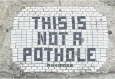  ?? Washington Post photos — The ?? One of Jim Bachor’s creations reads “This is not a pothole anymore.