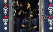  ?? JEFF ROBERSON/ AP ?? Members of the St. Louis Police Department SWAT team stage near the scene of a shooting Saturday. St. Louis police say themanwho shot two officerswa­s arrested Sunday morning after a 12-hour standoff.