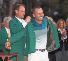  ?? ROB SCHUMACHER, USA TODAY SPORTS ?? Danny Willett, the 2016 Masters champ, continues the tradition of putting the green jacket on the winner, Sergio Garcia.