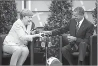  ?? AP/GERO BRELOER ?? Former U.S. President Barack Obama and German Chancellor Angela Merkel talk about democracy and global responsibi­lity at a Protestant conference Thursday in Berlin.