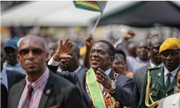  ?? AP ?? Zimbabwe's President Emmerson Mnangagwa, ( center), gestures to the cheering crowd as he leaves after the presidenti­al inaugurati­on ceremony in the capital Harare on Friday. —