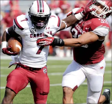  ?? NWA Media/ANDY SHUPE ?? South Carolina running back Shon Carson fends off Arkansas linebacker Jarrett Lake during the fourth quarter of the Gamecocks’ 52-7 victory Saturday in Fayettevil­le. Carson rushed for 56 yards on 15 carries and caught 1 pass for 14 yards.