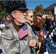  ??  ?? Mike Brown holds an American flag during the observance.