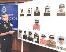  ?? - Bernama photo ?? Ayob Khan showing the photos of the 13 syndicate members believed to be involved in the country’s biggest drug haul worth RM201 million in the city two weeks ago.