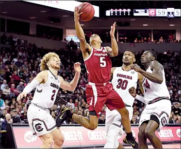  ?? Spurs and Feathers/ALLEN SHARPE ?? Arkansas sophomore guard Jalen Harris (5) gets off a shot between South Carolina defenders during the Razorbacks’ loss to the Gamecocks on Saturday at Colonial Life Arena in Columbia, S.C. Harris led Arkansas with 17 points, but the Hogs’ five-game winning streak ended.