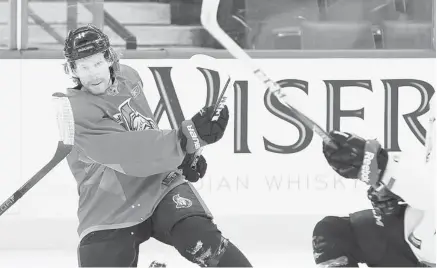  ?? JEAN LEVAC/OTTAWA CITIZEN ?? Daniel Alfredsson passes the puck as Zack Smith, partially obscured, tries to block it during practice at Scotiabank Place Friday.