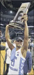  ?? BRANDON DILL / AP ?? North Carolina guard Nate Britt hoists the regional championsh­ip trophy after the Tar Heels beat Kentucky.