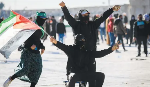  ?? (Jamal Awad/Flash90) ?? PROTESTERS WAVE a Palestinia­n flag as they clash with security forces at the al-Aqsa Mosque compound last month.