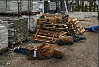  ?? ?? GRIM FIND: Dead bodies in the town of Bucha with one victim’s hands tied with a white cloth