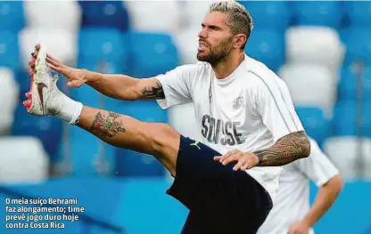  ?? Johannes Eisele/afp ?? O meia suíço Behrami faz alongament­o; time prevê jogo duro hoje contra Costa Rica