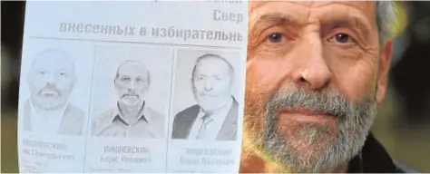  ?? // AFP ?? Boris Vishnevsky (en el cartel, a la derecha) muestra su foto y las de sus contrincan­tes electorale­s