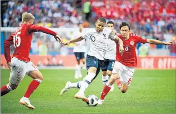  ?? FRANCK FIFE/GETTY-AFP ?? France’s Kylian Mbappe tries to dribble the ball through the Denmark defense during group play Tuesday in Moscow.