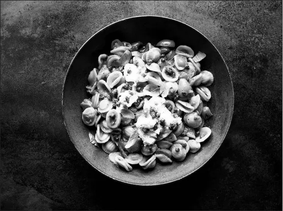  ?? DAVID MALOSH / THE NEW YORK TIMES ?? Spicy and saucy cherry tomato pasta can be made with ruby-red cherry tomatoes still warm from the summer sun. The secret is cooking down the tomatoes until they burst and their juices caramelize, and adding a little tomato paste to bolster their flavor.