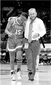  ?? ELSA/GETTY ?? Texas’ Kyra Lambert, left, walks off the court with coach Vic Schaefer after the first half against Maryland on Sunday at the Alamodome.