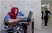  ??  ?? An employee works with her laptop at Takhfifan company in Tehran.