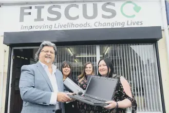  ??  ?? RB Group’s Kevin Floyd donates laptops and projector to Fiscus’s Anita Heskett-Saddington with, back, from left, charity staff Joanna Elliott and Courtney Knowles.