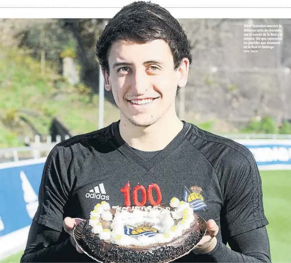  ?? FOTO: UNCITI ?? Mikel Oyarzabal muestra la deliciosa tarta de chocolate con el escudo de la Real y el número 100 que representa los partidos que alcanzará en la Real el domingo