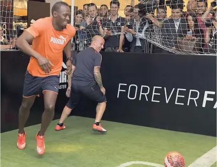  ??  ?? Jamaican sprinter Usain Bolt (left) plays a mini football match against Argentina internatio­nal Dario Benedetto during a promotiona­l event in Mexico City in 2015.