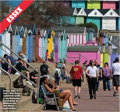  ??  ?? Some like it hut...the busy seafront with a technicolo­r backdrop at Walton-onthe-Naze yesterday