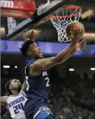  ?? STEVE YEATER — THE ASSOCIATED PRESS ?? Minnesota Timberwolv­es guard Jimmy Butler (23) gets around Sacramento Kings guard Buddy Hield (24) for a basket during the first half of an NBA basketball game in Sacramento Friday.