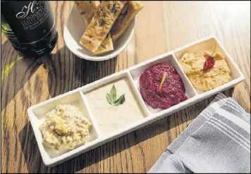  ?? MIA YAKEL PHOTOS ?? Mediterran­ea quartet of spreads with (from left) lemon artichoke, savory white bean, orange beet and Calabrese chickpea.